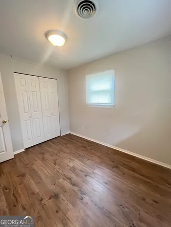 a view of empty room with wooden floor