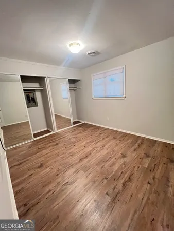a view of empty room with wooden floor
