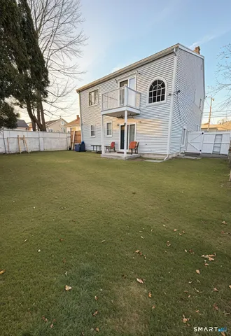 a view of a white house with a big yard