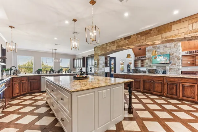 a kitchen with stainless steel appliances granite countertop a sink and a stove top oven