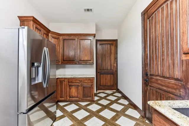 a kitchen with stainless steel appliances granite countertop a refrigerator and a sink