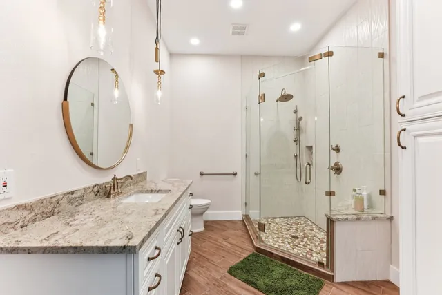 a bathroom with a granite countertop sink a shower and a mirror