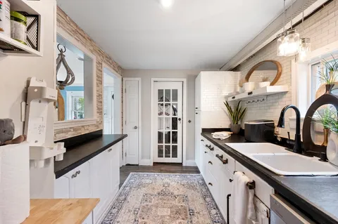 a spacious bathroom with a double vanity sink a mirror a and a window