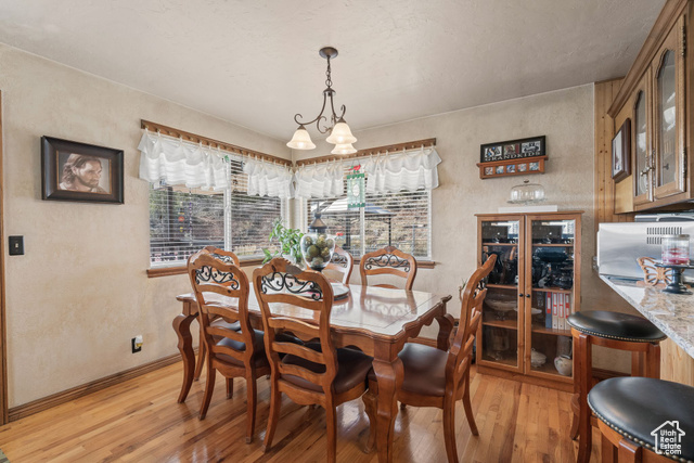 6407 North Dry Frk Cyn Road West Vernal, UT 84078 - Photo 22 of 48 Dining area featuring light wood finished floors, baseboards, a textured wall, and a chandelier