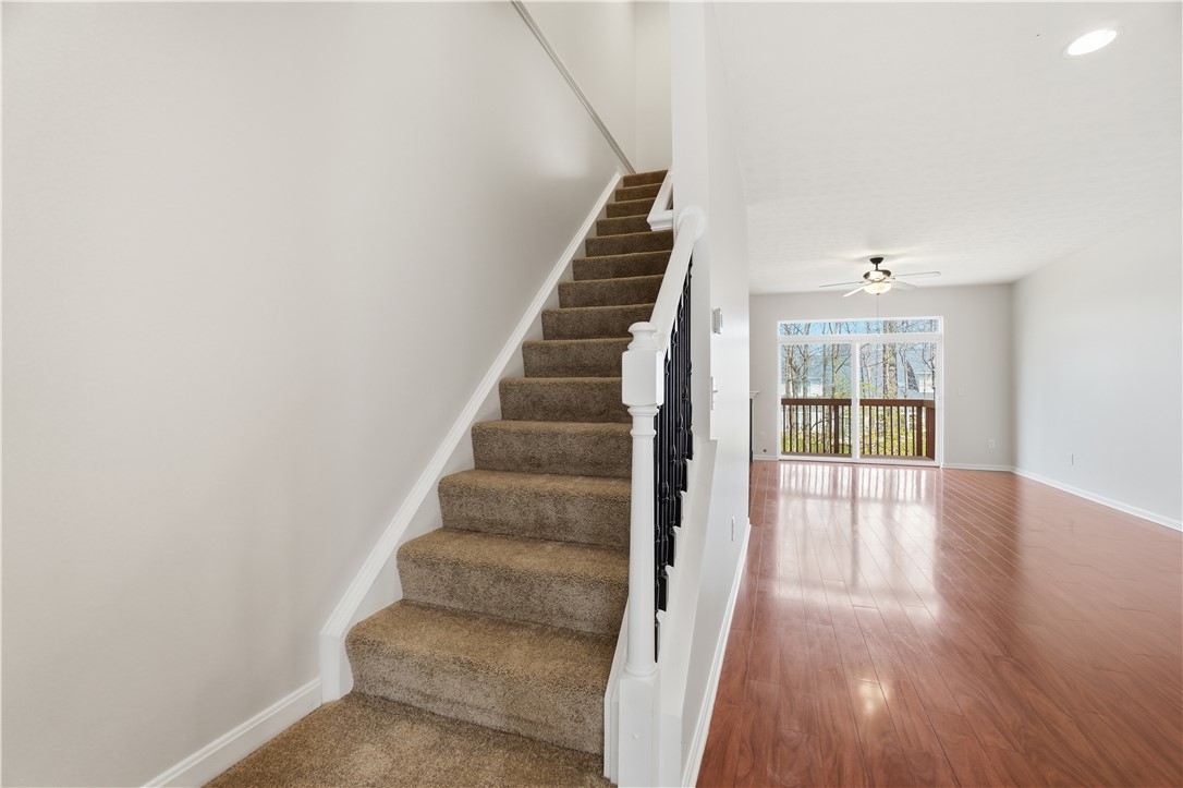 4294 Straight Arrow Road Dayton, OH 45430 - Photo 18 of 41 This bright space features a carpeted staircase leading to an inviting living area with rich hardwood flooring.