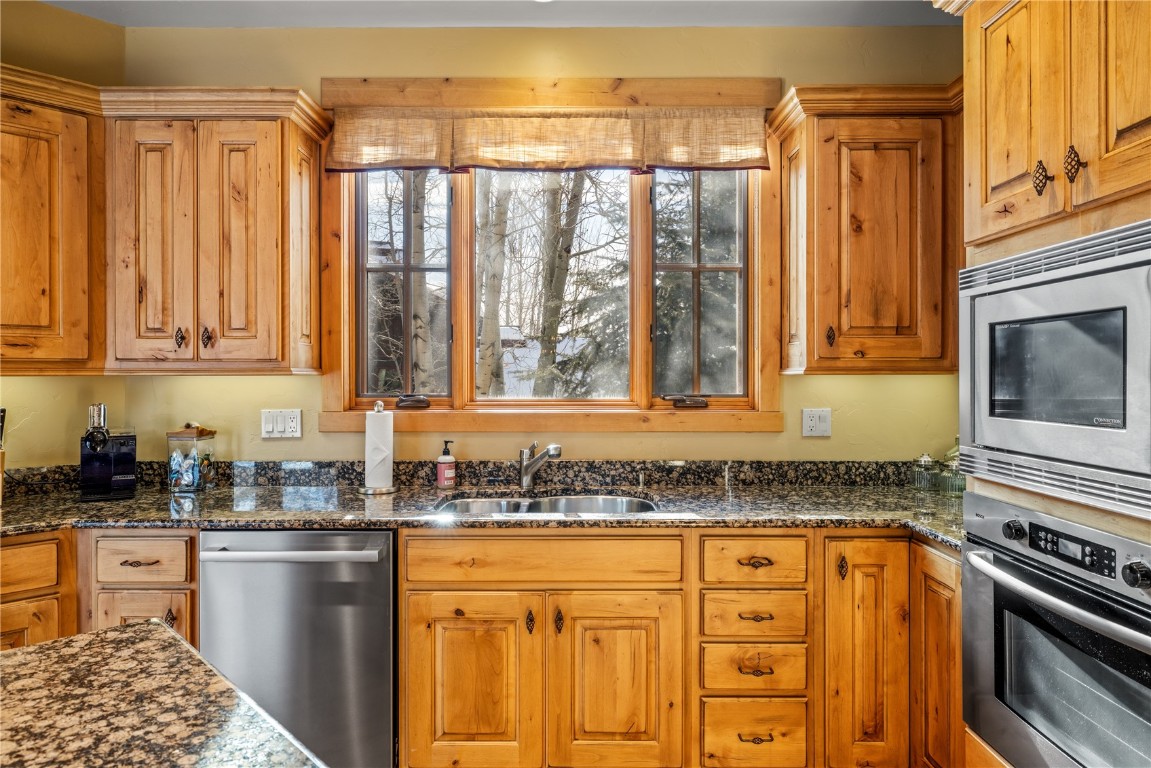 3258 Snowflake Circle, Unit 2 Steamboat Springs, CO 80487 - Photo 12 of 45 a kitchen with stainless steel appliances granite countertop a stove a sink and a microwave