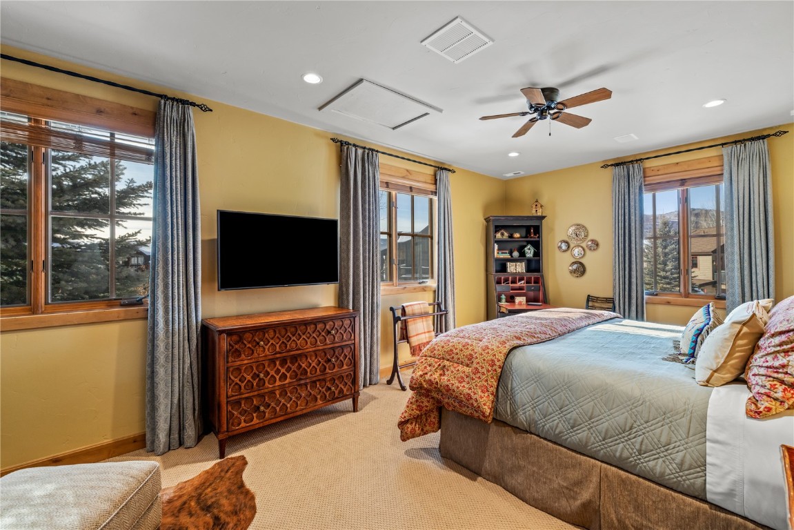 3258 Snowflake Circle, Unit 2 Steamboat Springs, CO 80487 - Photo 17 of 45 a bedroom with a large bed and a flat tv screen