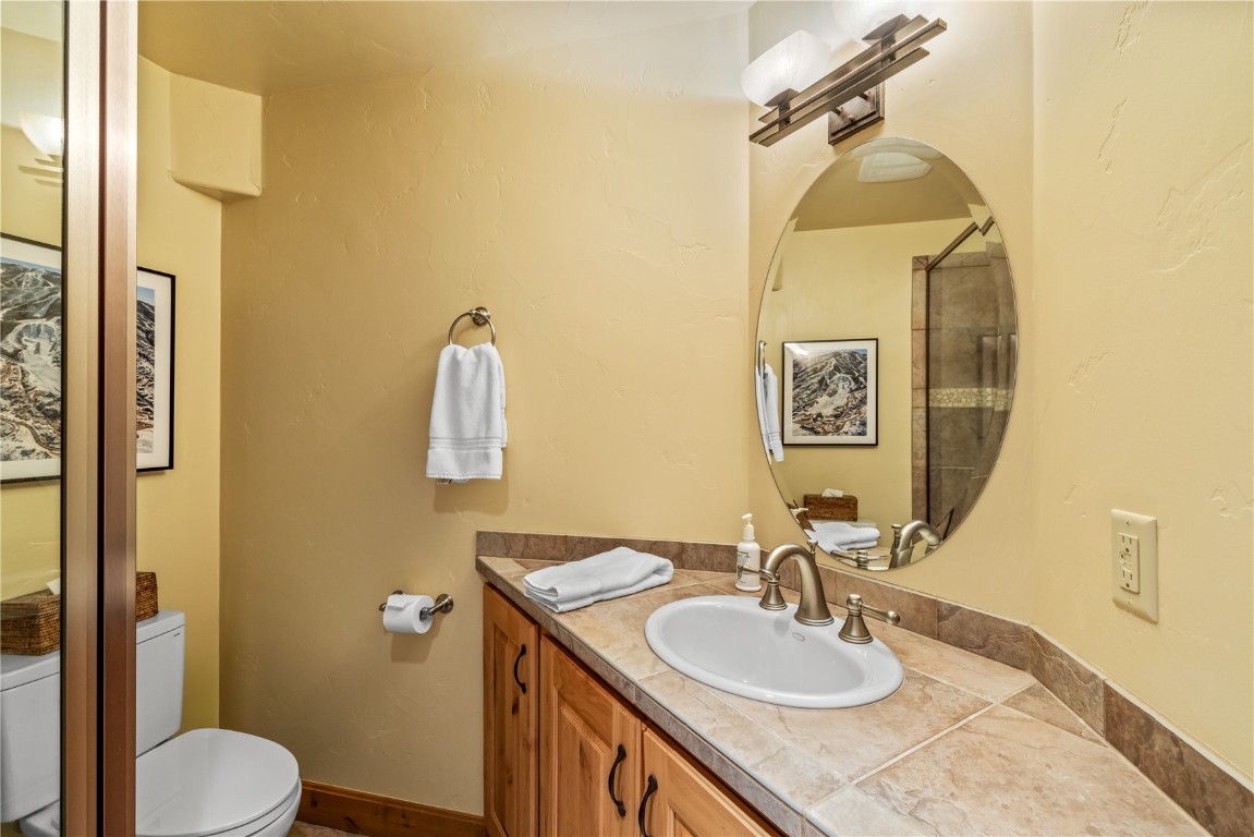 3258 Snowflake Circle, Unit 2 Steamboat Springs, CO 80487 - Photo 26 of 45 a bathroom with a granite countertop sink toilet and a mirror