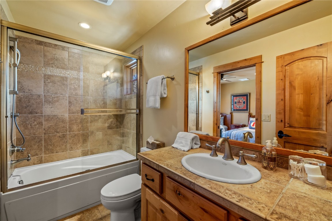 3258 Snowflake Circle, Unit 2 Steamboat Springs, CO 80487 - Photo 30 of 45 a bathroom with a granite countertop sink toilet mirror and shower