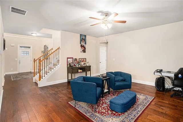 a living room with furniture and a wooden floor