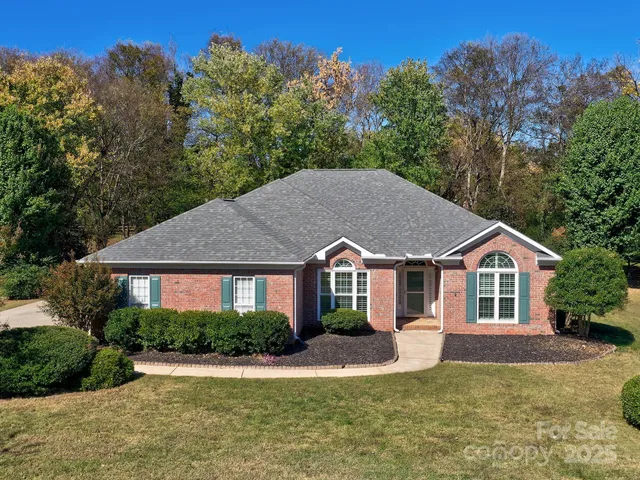 a view of a house with a yard and potted plants