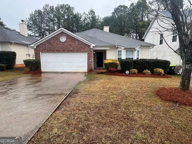 a view of a house with a yard and large trees