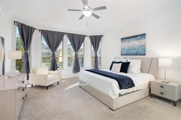 a spacious bedroom with a bed and large windows