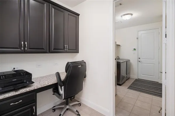 a view of a workspace with furniture and a window