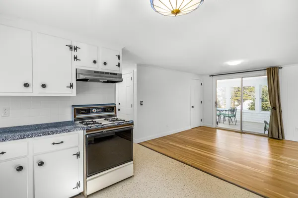 a kitchen with stainless steel appliances a stove and white cabinets
