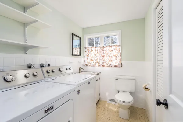 a bathroom with a sink toilet and window