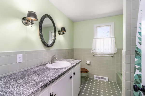 a bathroom with a granite countertop sink a mirror and a shower