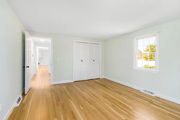 a view of empty room with wooden floor