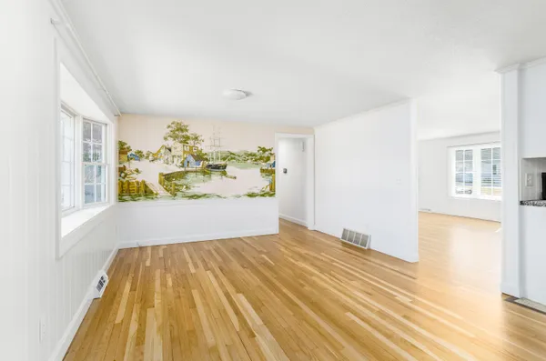 a view of a bedroom with wooden floor and a window
