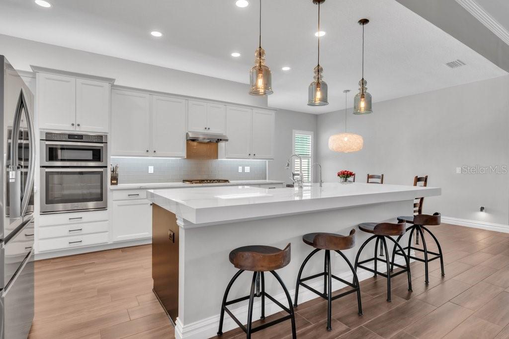 14908 Bassinger Lane Lithia, FL 33547 - Photo 11 of 56 a kitchen with stainless steel appliances a stove a sink island and a refrigerator
