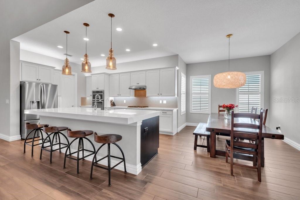 14908 Bassinger Lane Lithia, FL 33547 - Photo 10 of 56 a kitchen with a dining table chairs wooden floor and appliances