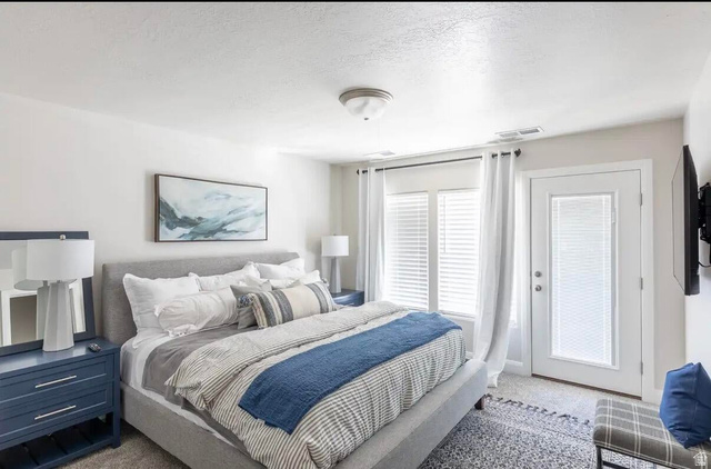 4846 Fishers Is Way St. George, UT 84770 - Photo 9 of 13 Bedroom featuring light gray carpet, an upholstered bed frame, and white walls