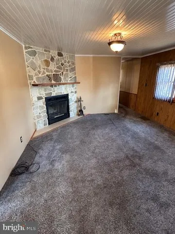 a view of empty room with fireplace and fan