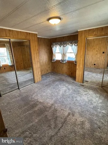 a view of empty room with wooden floor and windows