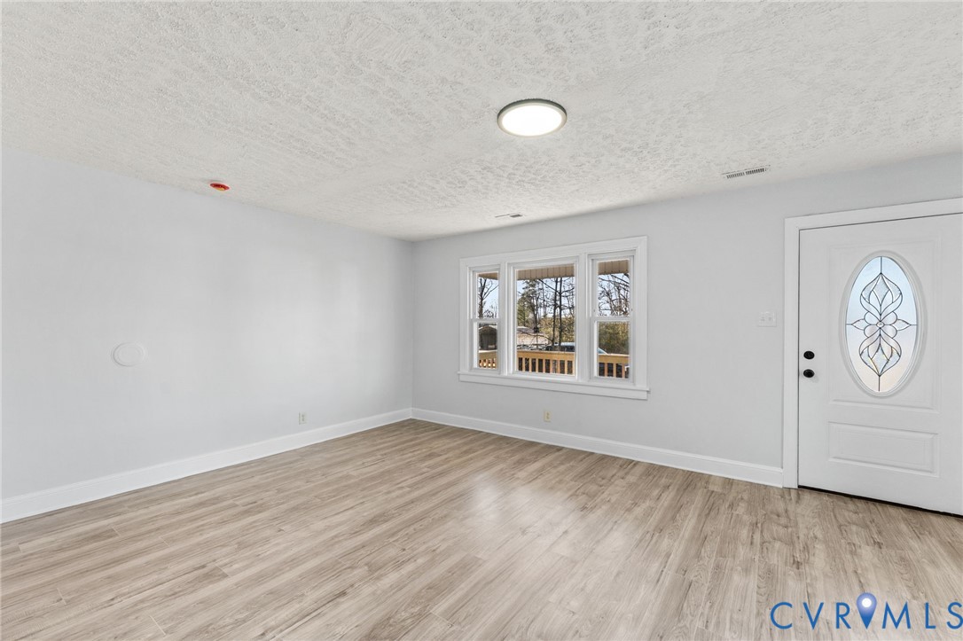352 3rd Street Emporia, VA 23847 - Photo 2 of 25 an empty room with wooden floor and window