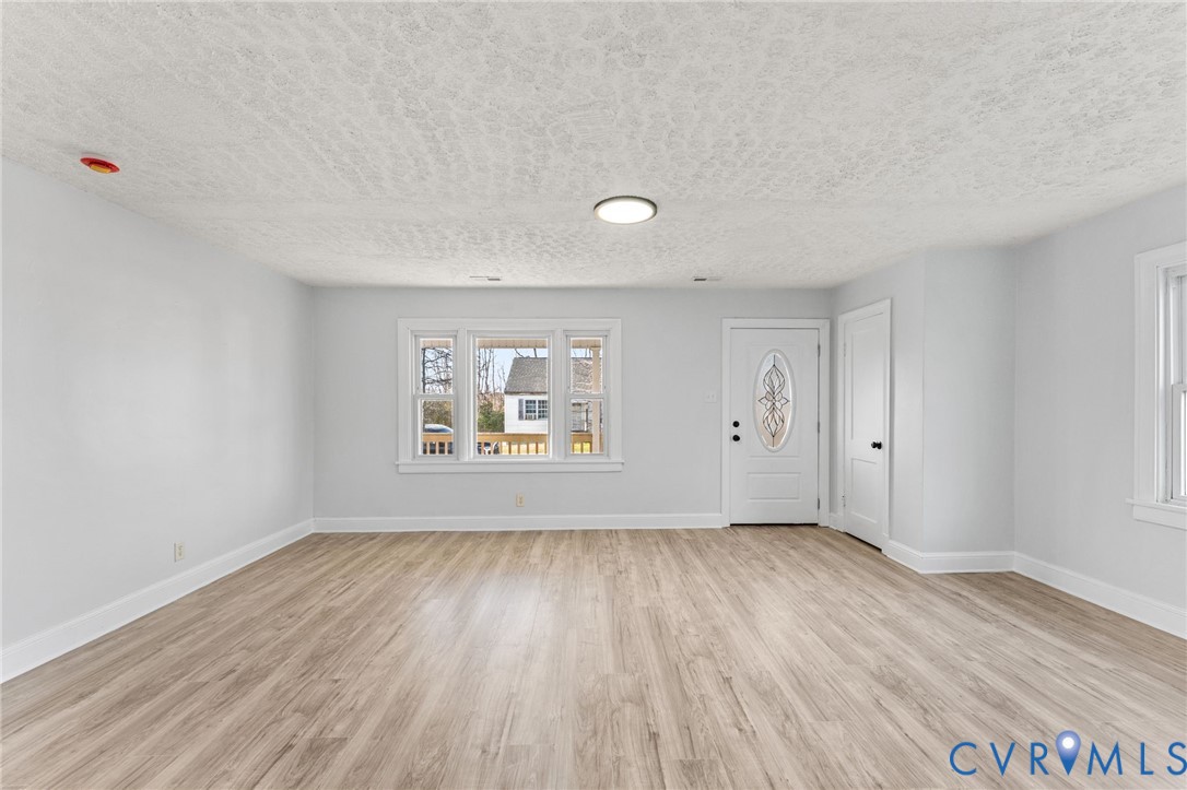 352 3rd Street Emporia, VA 23847 - Photo 3 of 25 a view of an empty room with wooden floor and a window