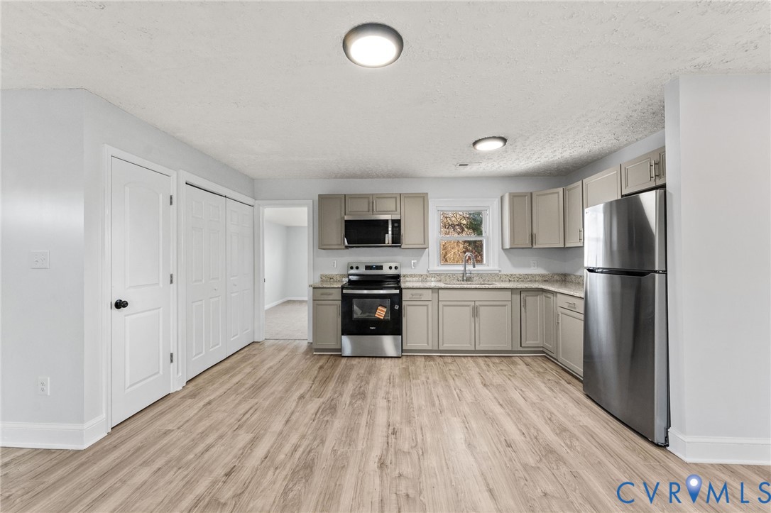352 3rd Street Emporia, VA 23847 - Photo 5 of 25 a kitchen with a refrigerator a stove top oven and white cabinets