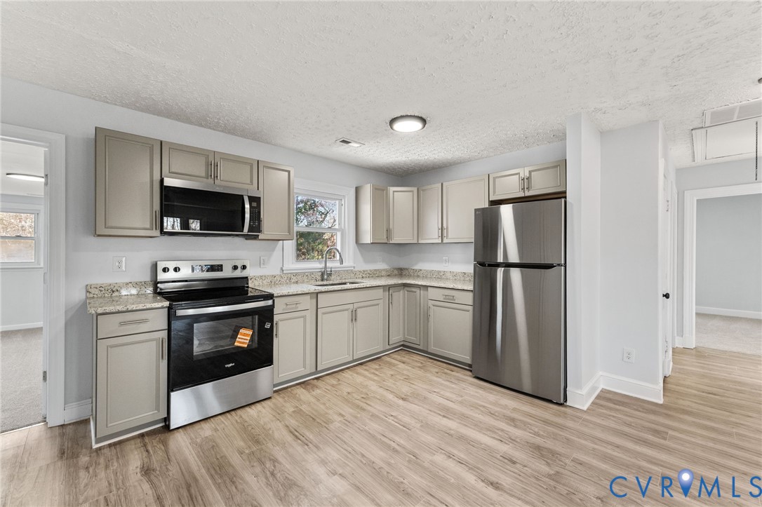 352 3rd Street Emporia, VA 23847 - Photo 6 of 25 a kitchen with granite countertop a refrigerator stove and wooden floor