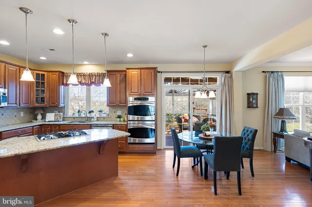 a dining room with furniture potted plants and wooden floor