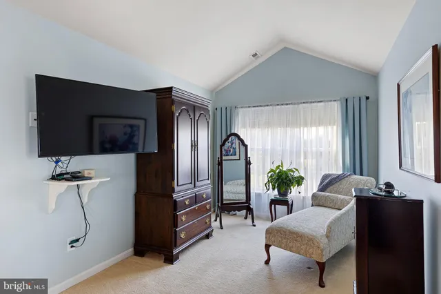 a bedroom with a bed and large windows