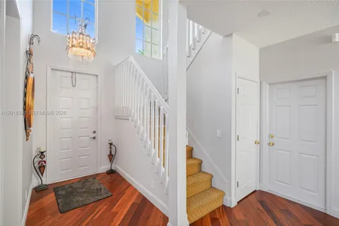 a view of a hallway with wooden floor and staircase