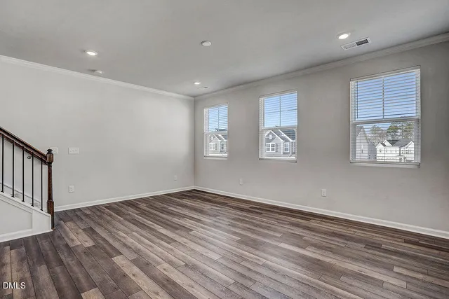 a view of empty room with wooden floor