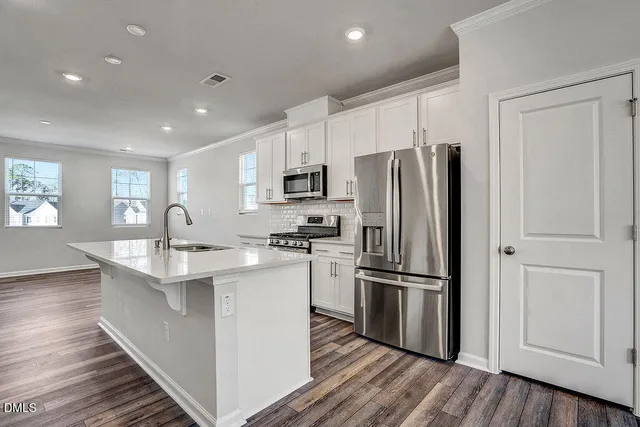 a kitchen with stainless steel appliances granite countertop a refrigerator stove and sink