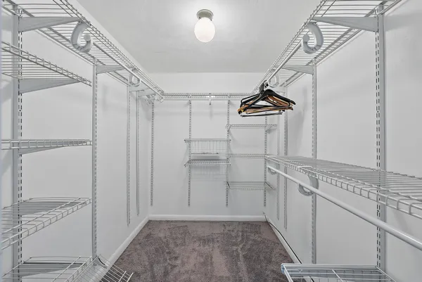 a view of a kitchen with white cabinets and wooden floor