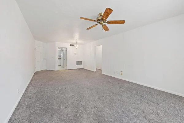 a view of a livingroom with a ceiling fan and wooden floor