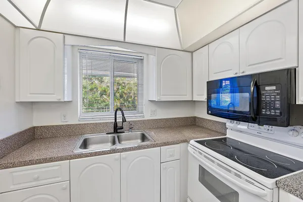 a kitchen with stainless steel appliances granite countertop a sink a stove and cabinets