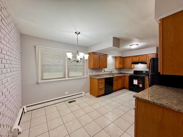 a large kitchen with a large counter top and stainless steel appliances