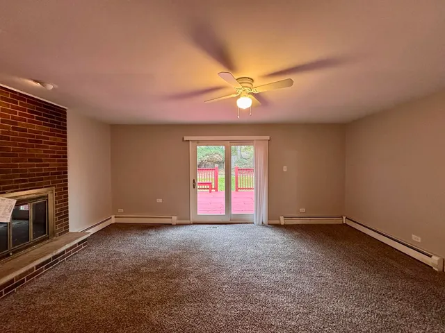 a view of empty room with window and fireplace