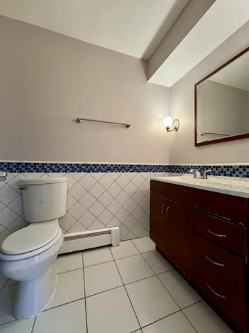 a bathroom with a granite countertop toilet and a sink