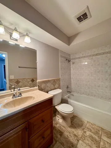 a spacious bathroom with a bathtub shower sink mirror and toilet