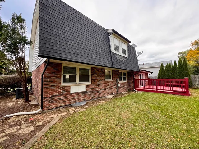 a view of a house with a yard and sitting area