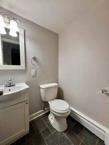 a bathroom with a toilet a sink and mirror