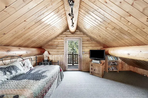 a bedroom with furniture and a flat screen tv