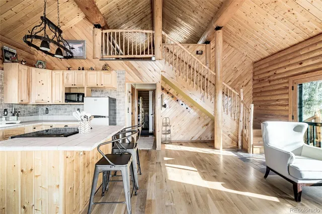 a kitchen with granite countertop a stove a sink and a dining table with chairs