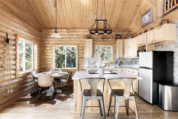 a dining room with furniture a chandelier and wooden floor