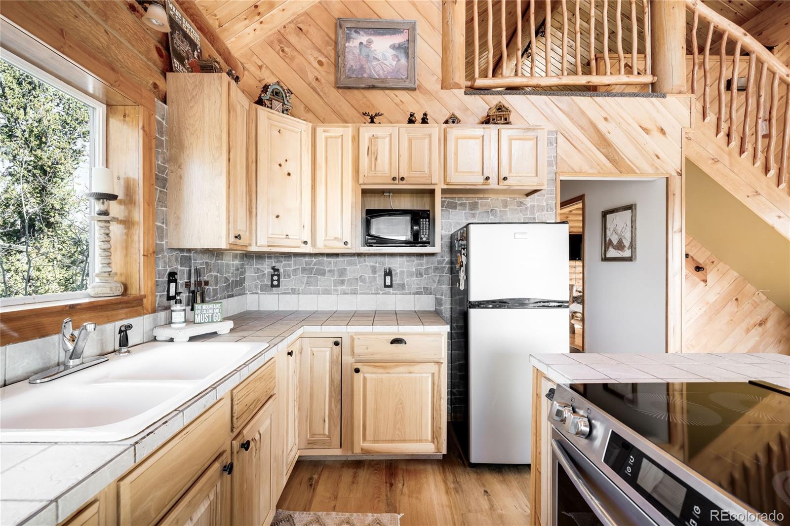43 Pintail Way Como, CO 80432 - Photo 10 of 48 a kitchen with a sink dishwasher a stove and a refrigerator with wooden floor
